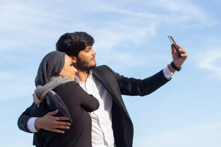loving-arabic-couple-taking-selfie-woman-with-covered-head-bright-make-up-man-suit-picturing-themselves-with-mobile-phone-love-affection-concept-min-scaled-1